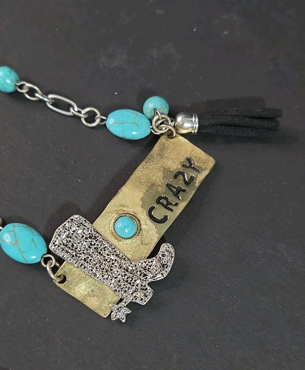 Oddly Darling Vintage western statement necklace with a silver cowboy boot, brass CRAZY plate, and turquoise beads.