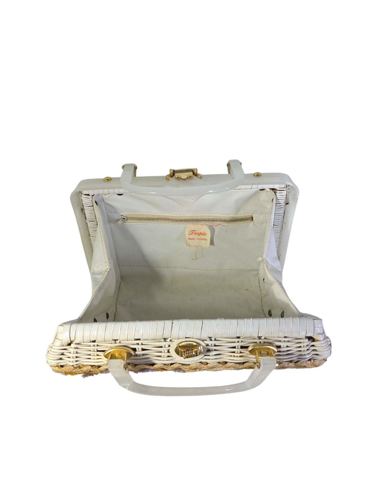Tropic wicker purse opened wide showing the white vinyl lining, zippered pocket and Tropic label