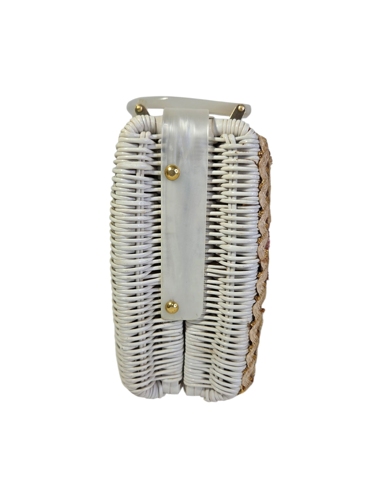 End of the white painted wicker purse with a pearlized Lucite strap held by two gold-tone studs