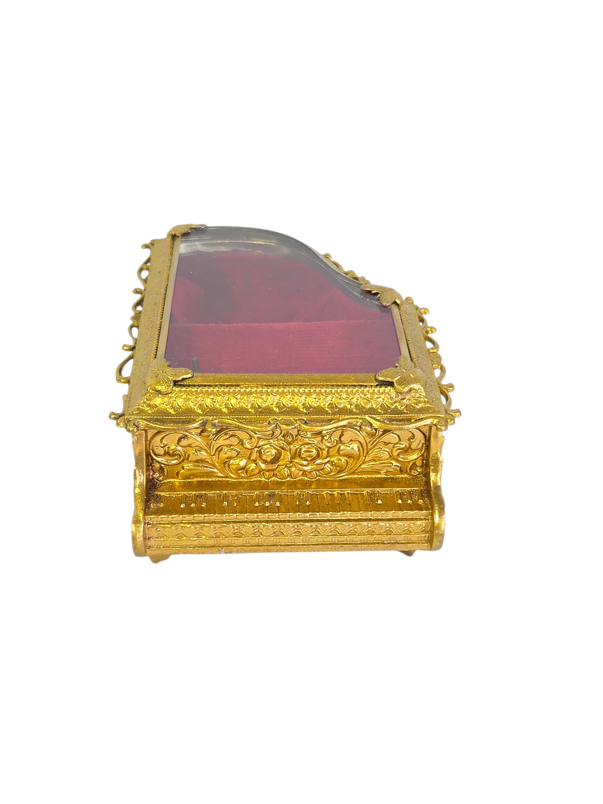 Bottom of the gold-tone piano jewelry box showing the music box winding key and two screws, unmarked