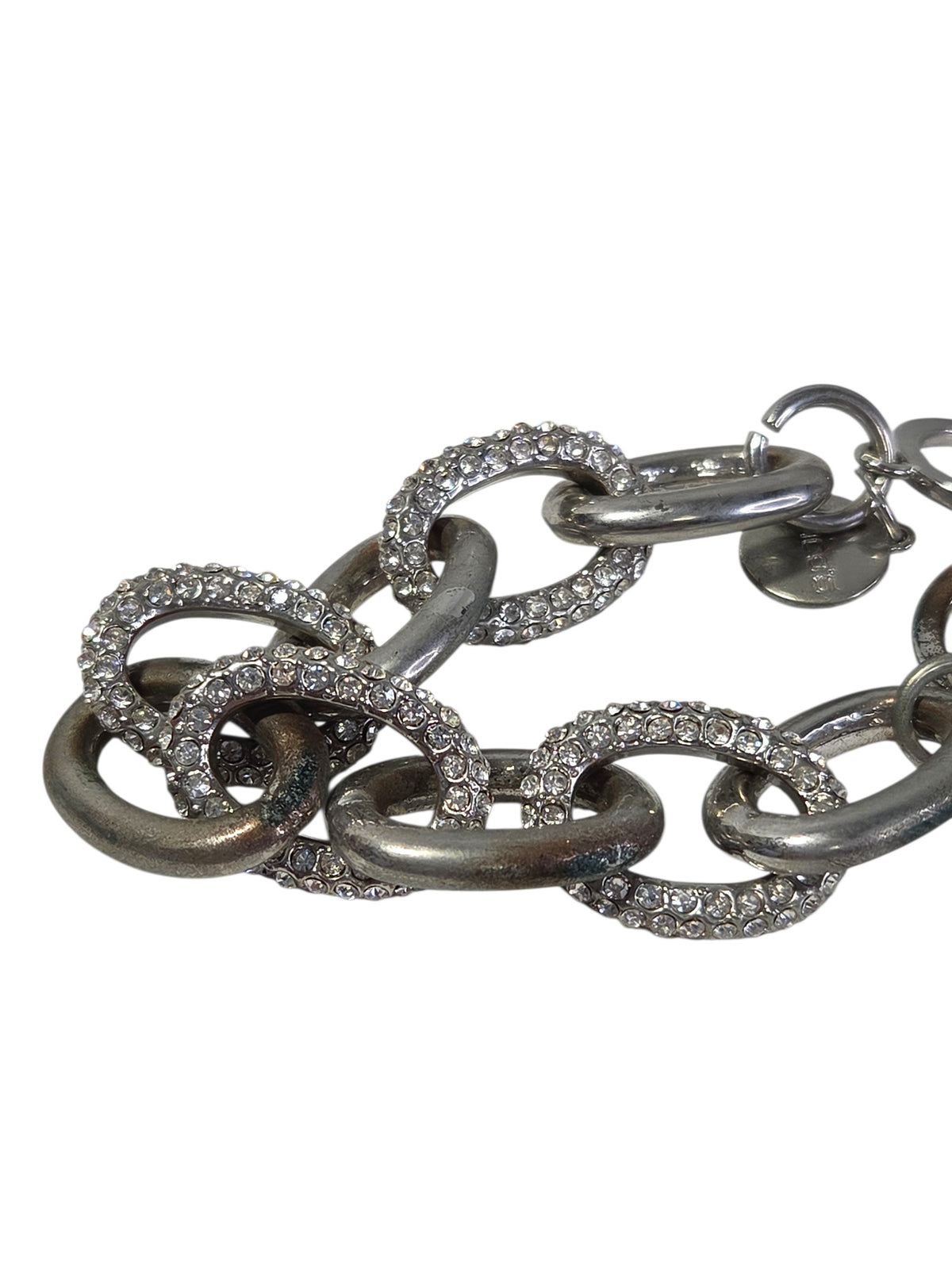 Round Chico's logo tag charm hanging by the toggle ring on the chunky link bracelet