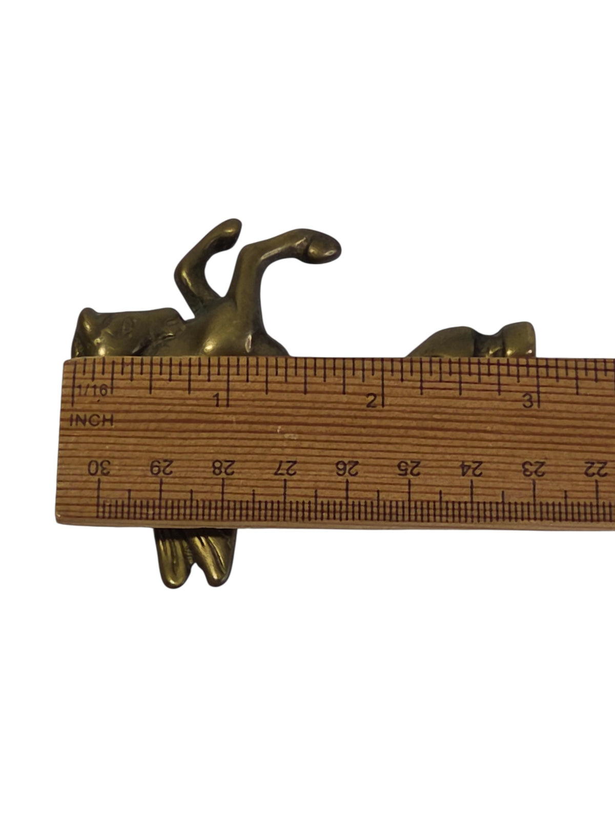 Brass Pegasus finial beside a ruler, about 3 inches long