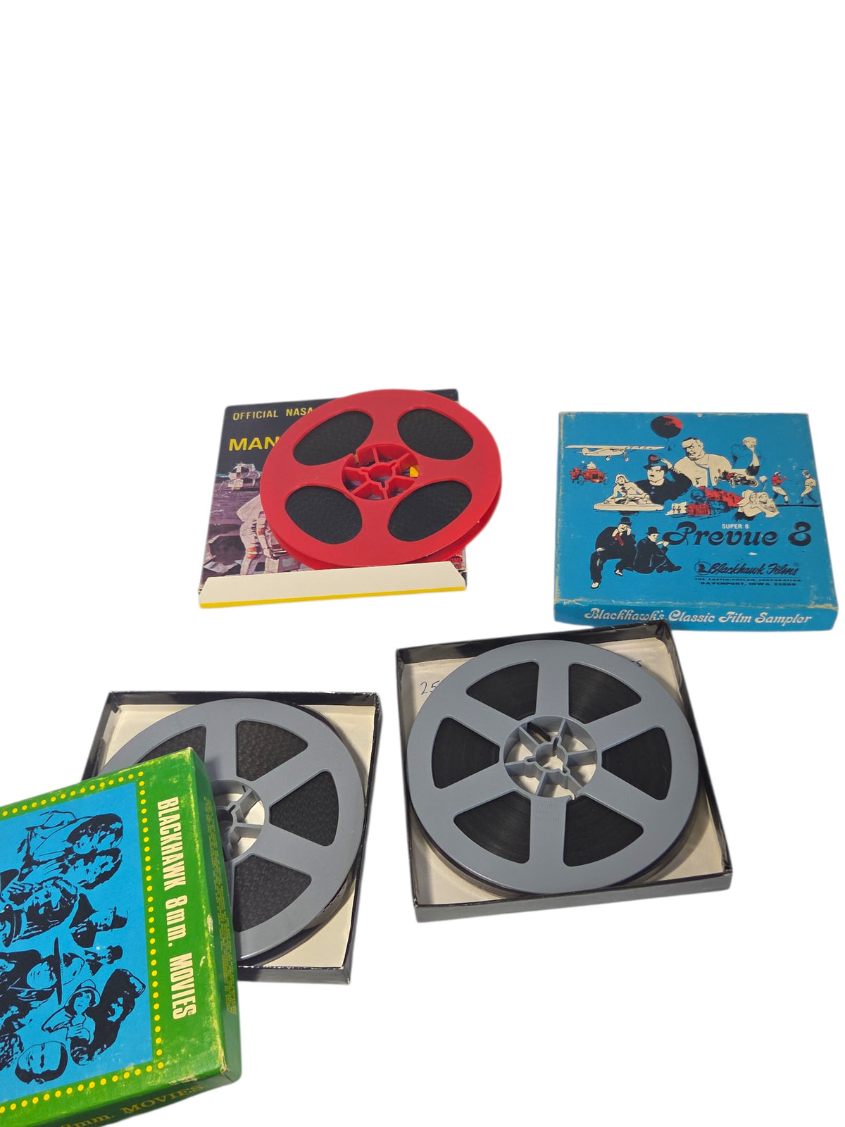 Super 8 films out of their boxes: Apollo 11 on a red reel and two Blackhawk films on gray reels