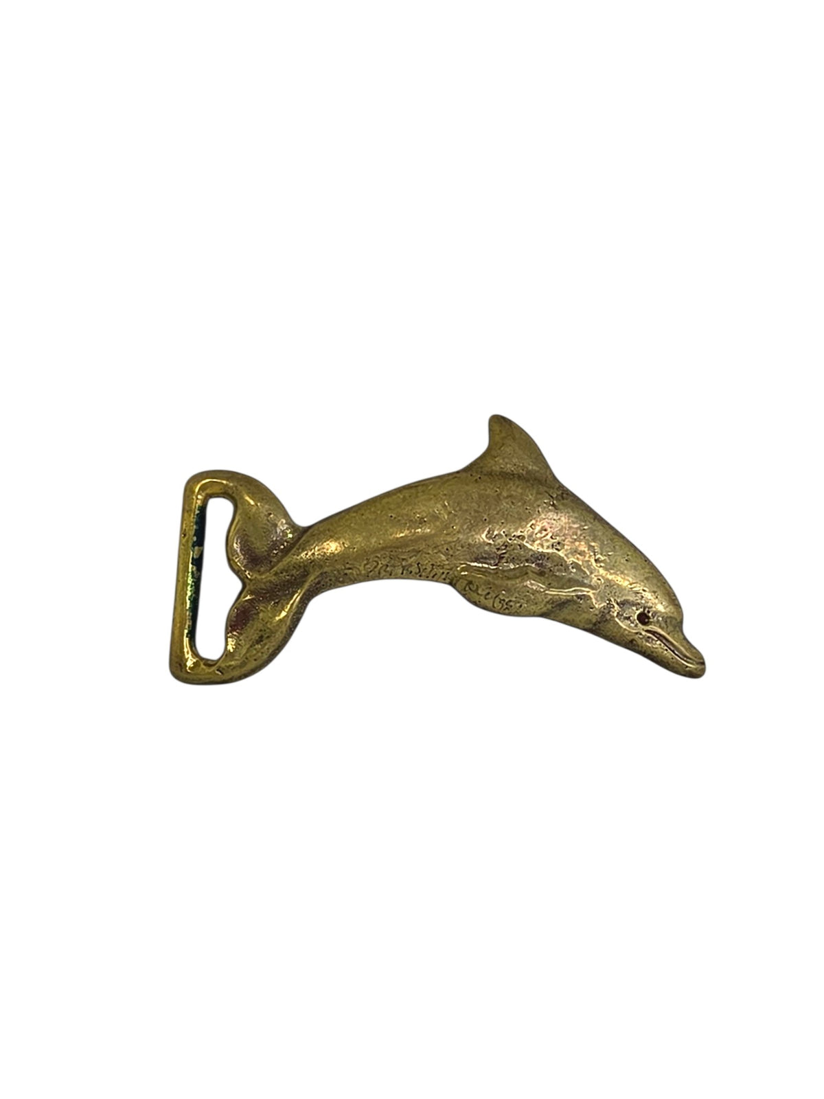 Vintage solid brass leaping dolphin belt buckle on white, tail curled into the belt loop