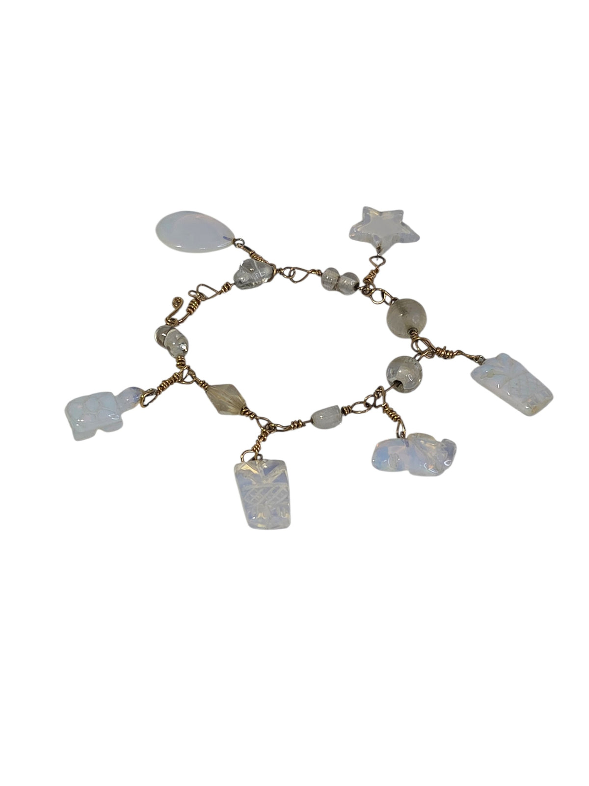Opalite charm bracelet laid flat at an angle, showing the glass beads between the six dangling charms
